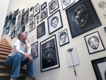 Lade das Bild in den Galerie-Viewer, Marilena Hamm alias Scribblezone in ihrem Atelier vor ihrer Scribble Wand an der eine Sammlung ihrer Portraits berühmter Persönlichkeiten hängen, die sie in ihrem unverwechselbaren Scribble-Stil gezeichnet hat.
